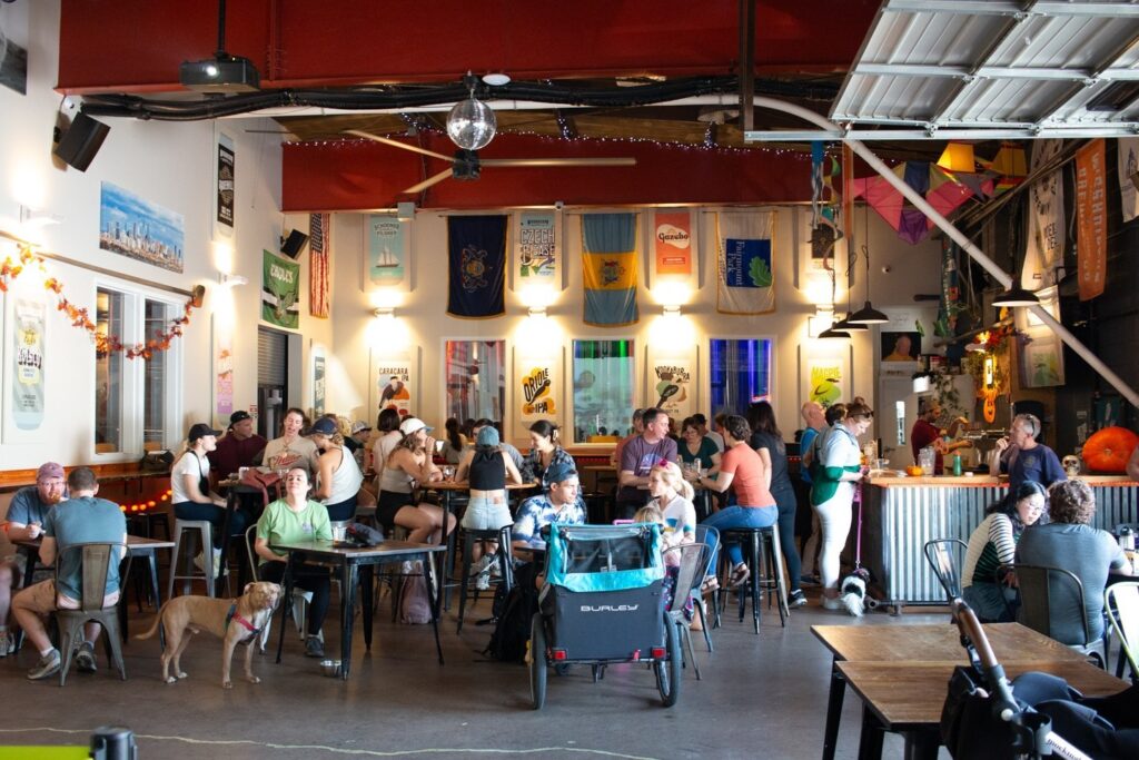 A photo shows a crowd of people enjoying beers at Wissahickon Brewing Company, East Falls. Philadelphia Brewery Contact Us.