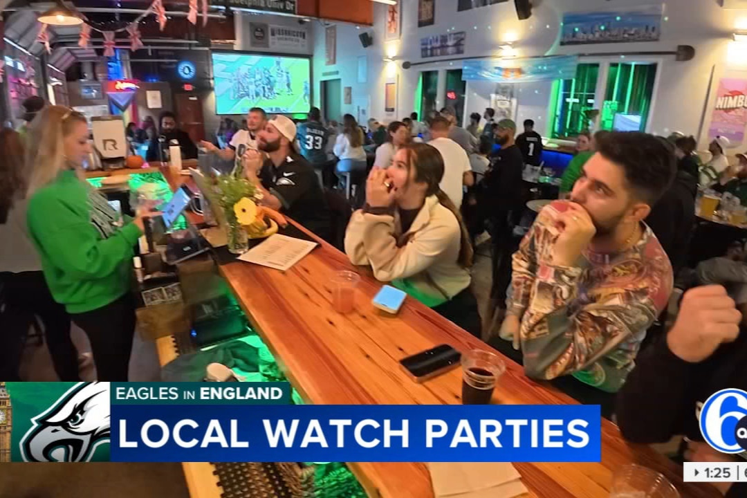 A photo shows a crowd of people sitting at the bar watching a football game. Featured on Local Philly Brewery News.